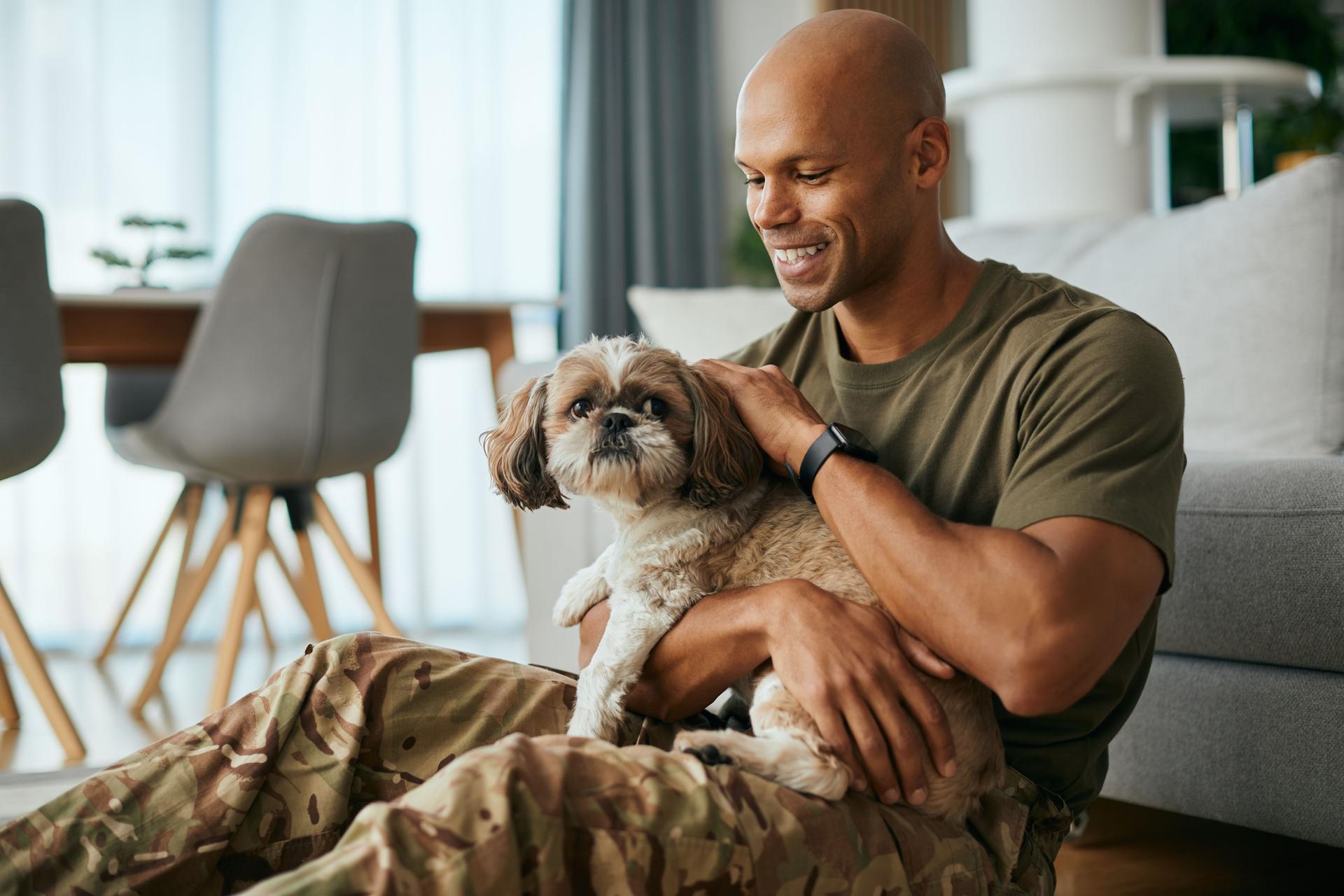 Happy black soldier enjoying with his dog after coming home from deployment.